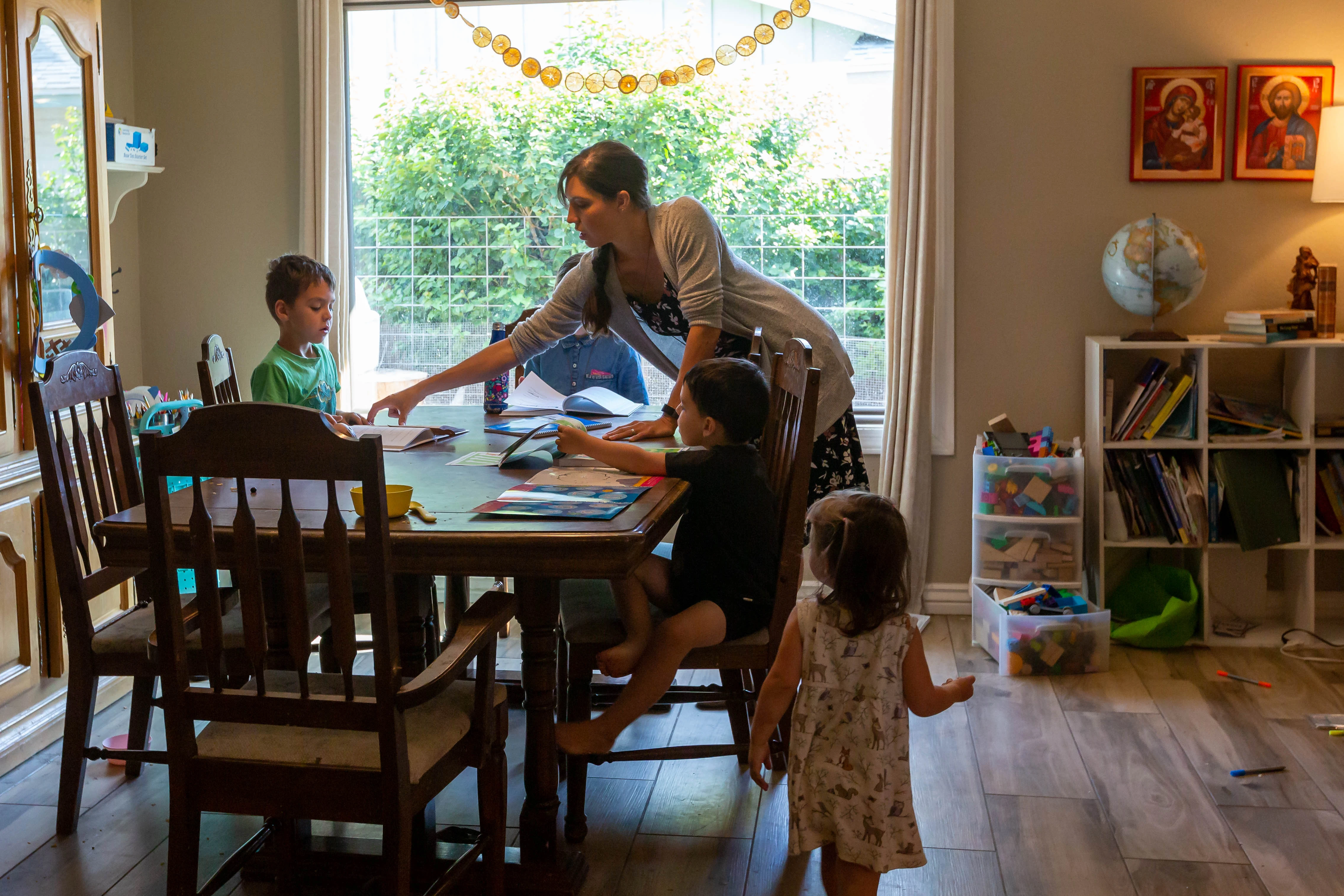 Maureen McKinley helps her children through some study exercises in her family's dining room in Phoenix. McKinley and her husband, Matt, home-school their five children and offer the older children a curriculum that includes Latin.?w=200&h=150